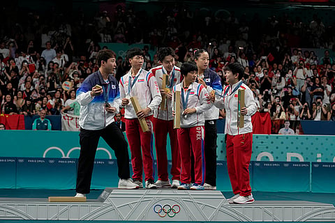 South Korea's Lim Jonghoon, left, prepares to take a selfie during table tennis medal ceremony